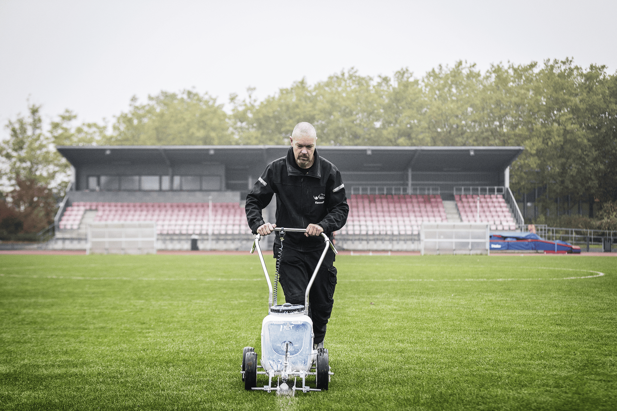 Billede af Kenneth der slår græs på en fodboldbane